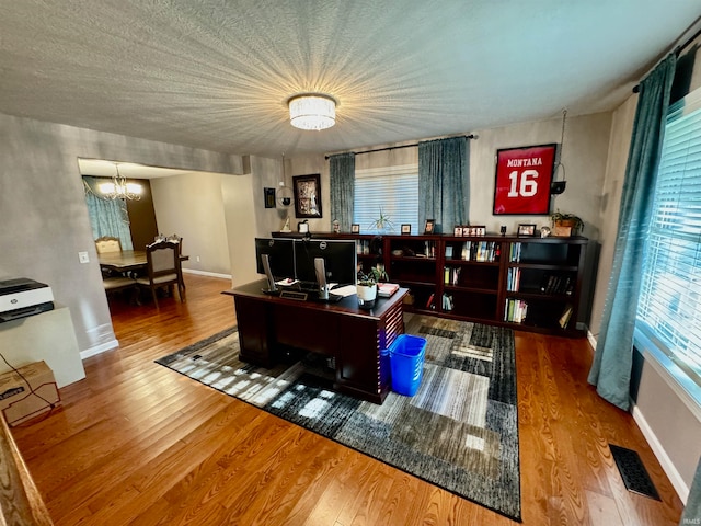 office space featuring hardwood / wood-style flooring and an inviting chandelier