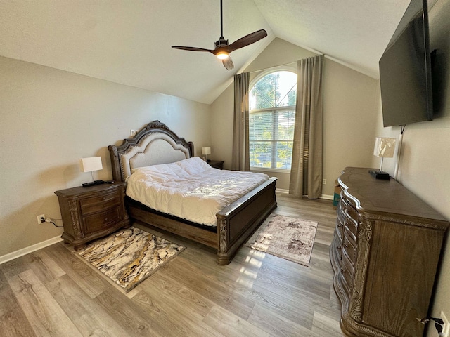 bedroom with ceiling fan, light hardwood / wood-style flooring, and lofted ceiling