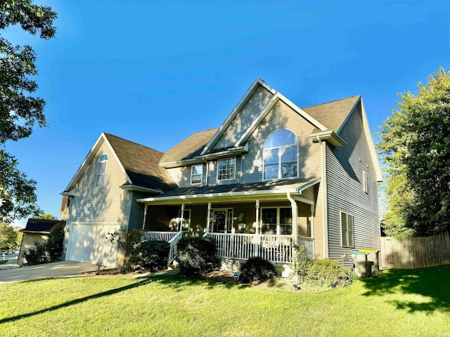 view of front of home featuring a porch, a garage, and a front lawn