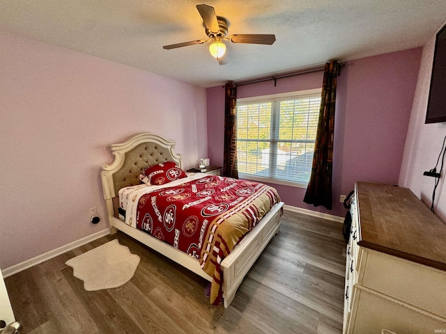 bedroom featuring ceiling fan, wood-type flooring, and a textured ceiling