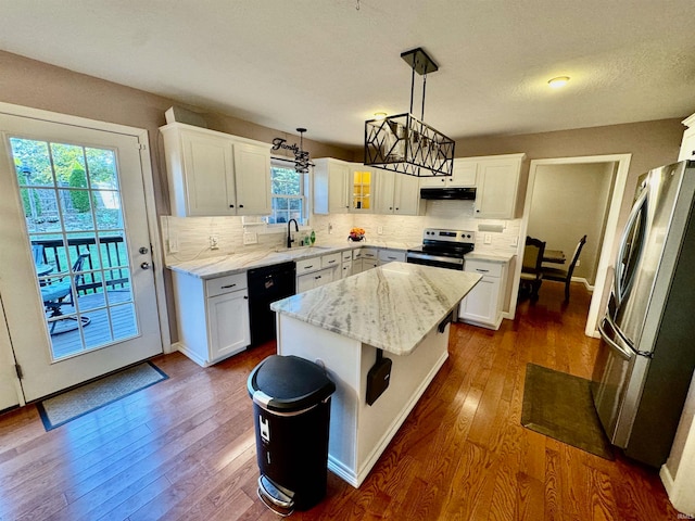 kitchen with a center island, white cabinets, pendant lighting, and appliances with stainless steel finishes