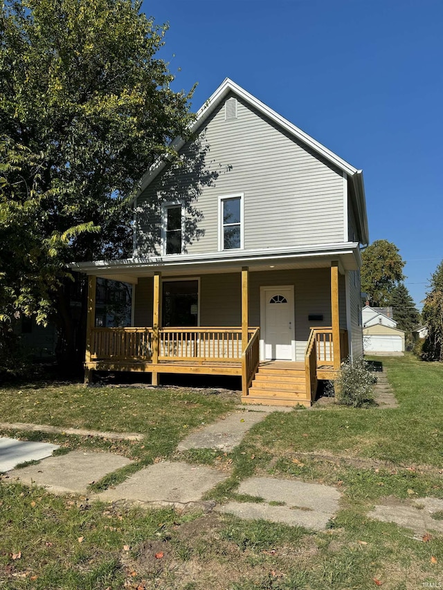 view of front of home featuring a front yard, a garage, and a porch