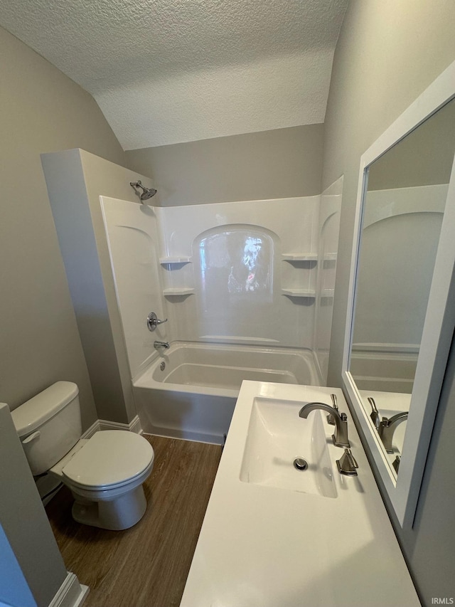 full bathroom with lofted ceiling, bathtub / shower combination, wood-type flooring, a textured ceiling, and toilet