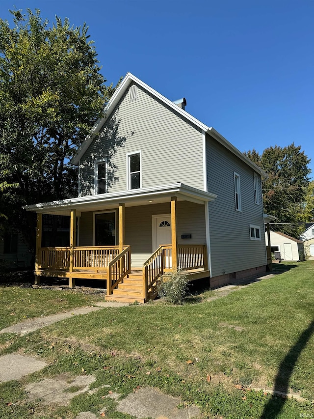 farmhouse featuring a front lawn and covered porch