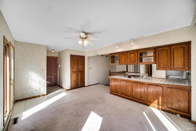 kitchen featuring light carpet, tile countertops, rail lighting, and ceiling fan