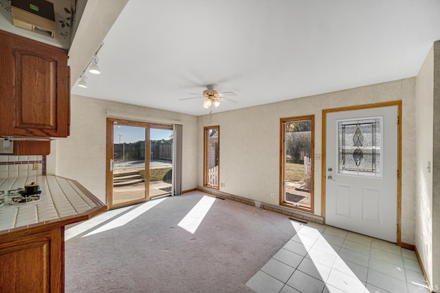 carpeted living room with ceiling fan and rail lighting