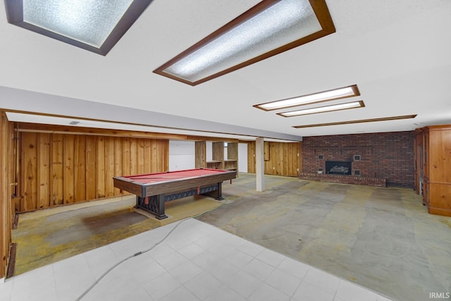 game room featuring wood walls, a brick fireplace, brick wall, and pool table