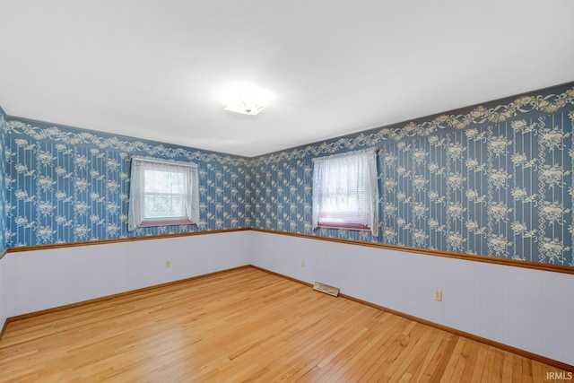 unfurnished room with plenty of natural light and wood-type flooring