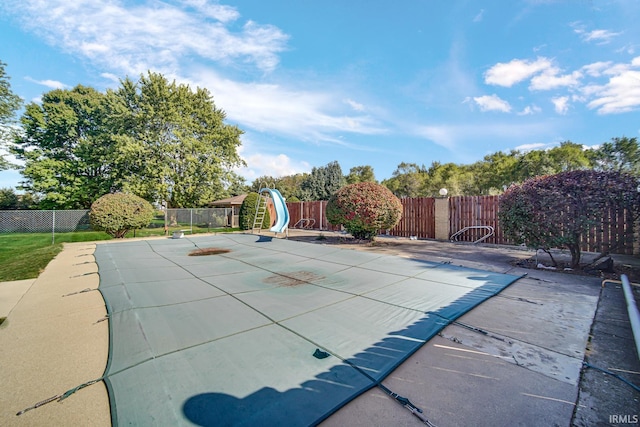 view of pool featuring a water slide and a patio area