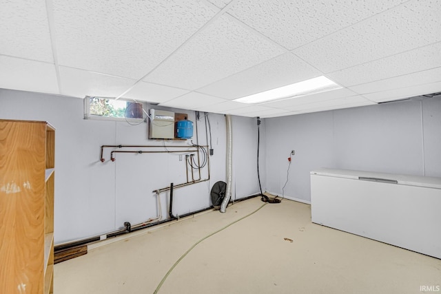 basement with refrigerator and a paneled ceiling