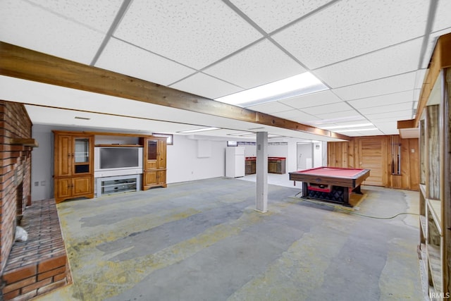 basement with white refrigerator, a drop ceiling, a fireplace, and pool table