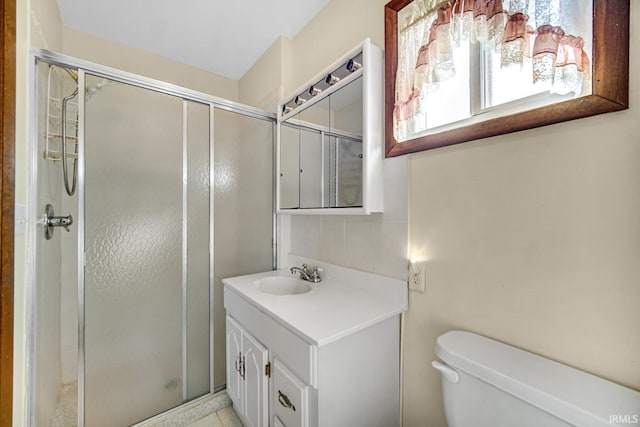 bathroom with vanity, tile patterned flooring, toilet, and a shower with door