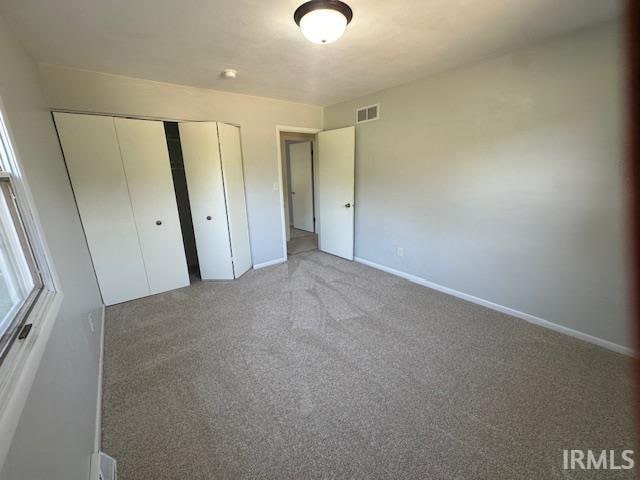 unfurnished bedroom with carpet floors and a closet