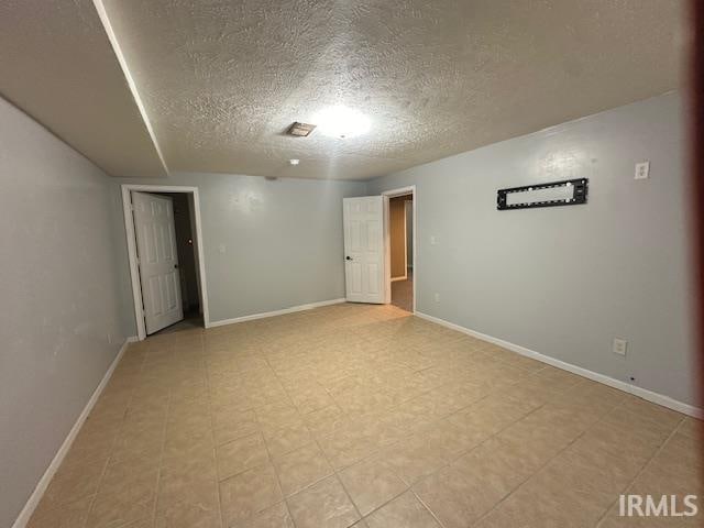 unfurnished room featuring a textured ceiling