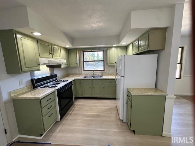 kitchen with green cabinetry, black range with gas cooktop, sink, and light hardwood / wood-style flooring