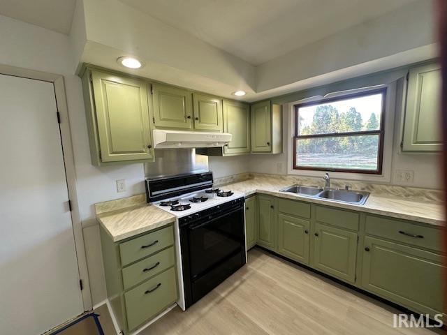 kitchen featuring green cabinetry, light hardwood / wood-style flooring, gas stove, and sink