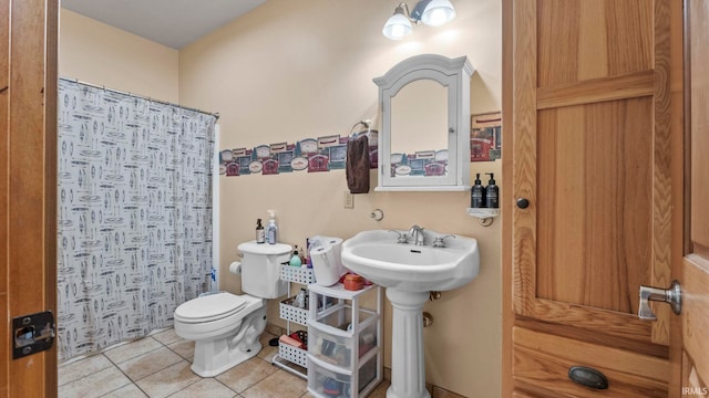 bathroom featuring tile patterned floors, a shower with shower curtain, and toilet