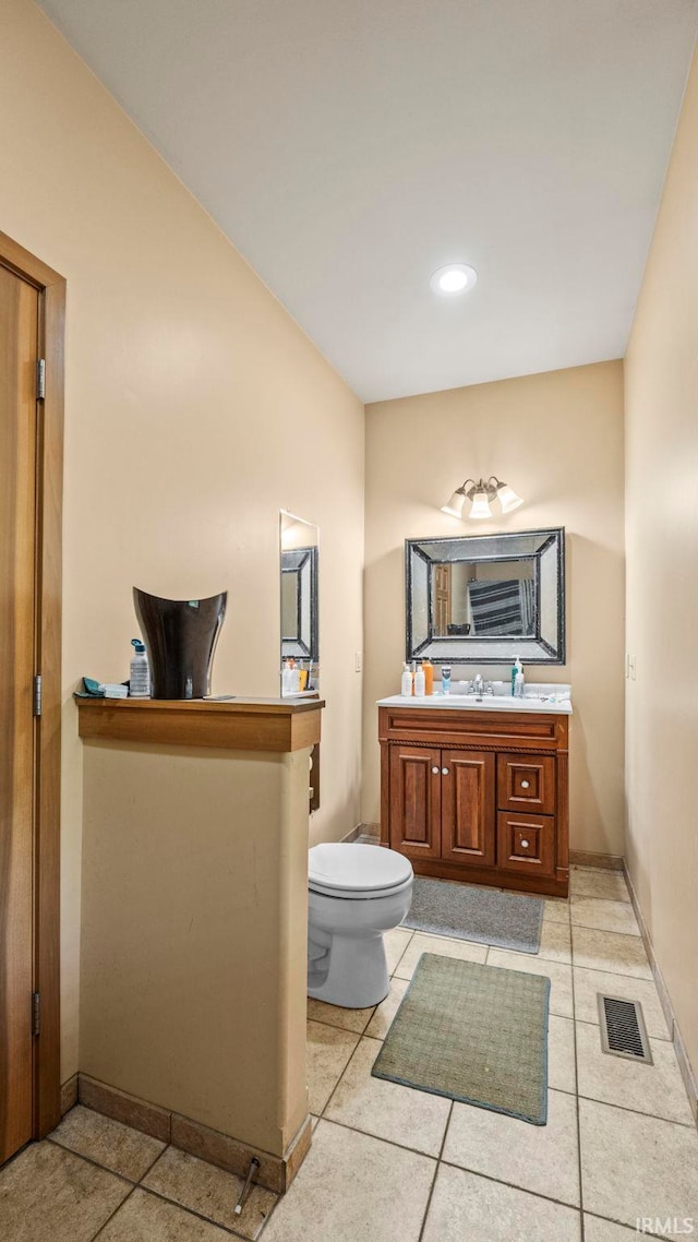 bathroom featuring vanity, tile patterned flooring, and toilet