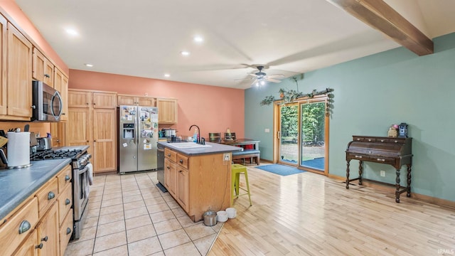 kitchen featuring sink, a kitchen island with sink, stainless steel appliances, a breakfast bar, and light wood-type flooring