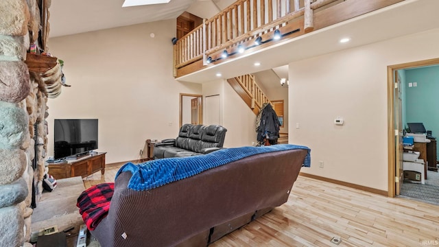 living room with light hardwood / wood-style flooring and high vaulted ceiling