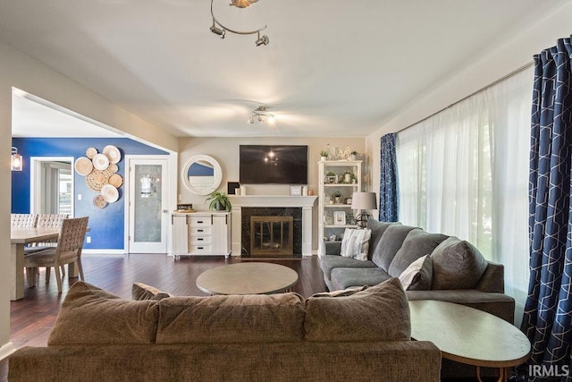 living room with dark hardwood / wood-style flooring and a healthy amount of sunlight