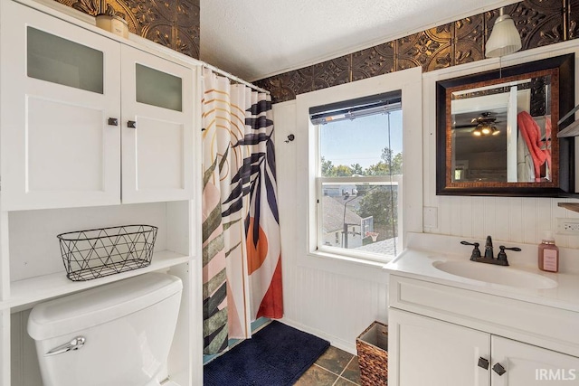 bathroom with tile patterned floors, vanity, toilet, and a textured ceiling