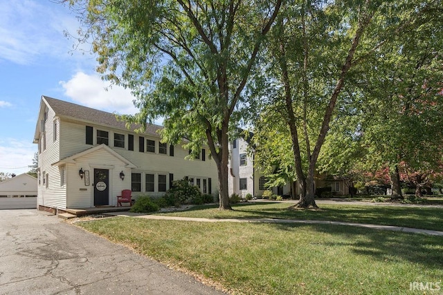 colonial inspired home featuring a front lawn