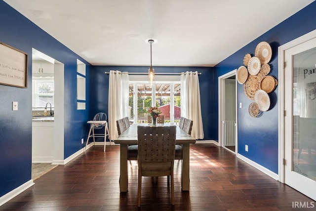 dining area featuring a wealth of natural light, sink, and dark hardwood / wood-style flooring