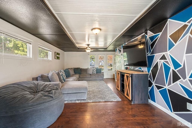 living room with ceiling fan, a wealth of natural light, and dark hardwood / wood-style flooring