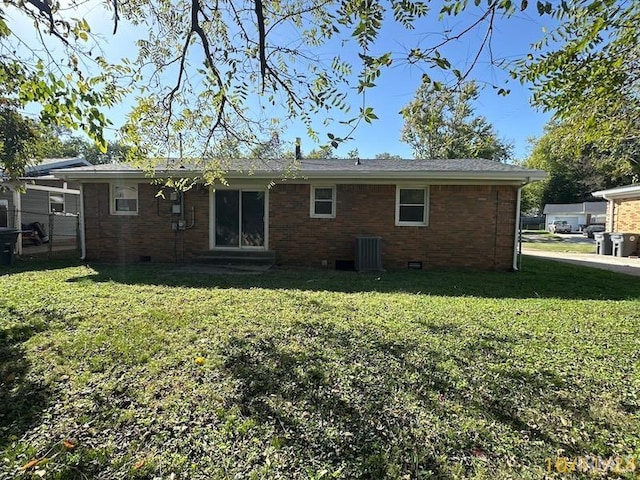 rear view of property featuring a yard and central air condition unit