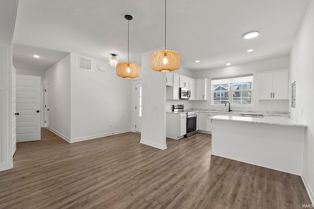 kitchen featuring pendant lighting, dark hardwood / wood-style flooring, sink, white cabinets, and appliances with stainless steel finishes