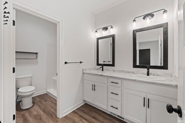 bathroom with hardwood / wood-style floors, vanity, and toilet