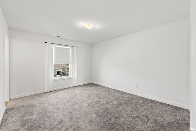 carpeted spare room with a textured ceiling