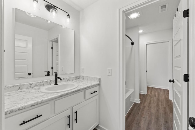 bathroom with shower / bathing tub combination, vanity, and hardwood / wood-style flooring