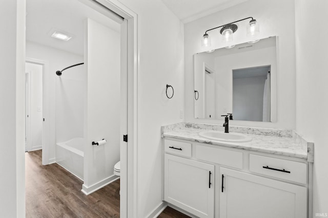 full bathroom featuring bathing tub / shower combination, wood-type flooring, vanity, and toilet