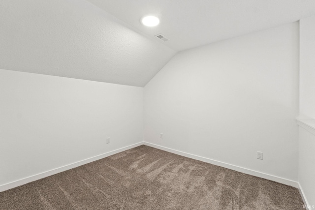 bonus room with lofted ceiling and carpet flooring