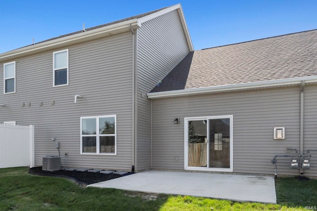 back of property with a yard, central air condition unit, and a patio area