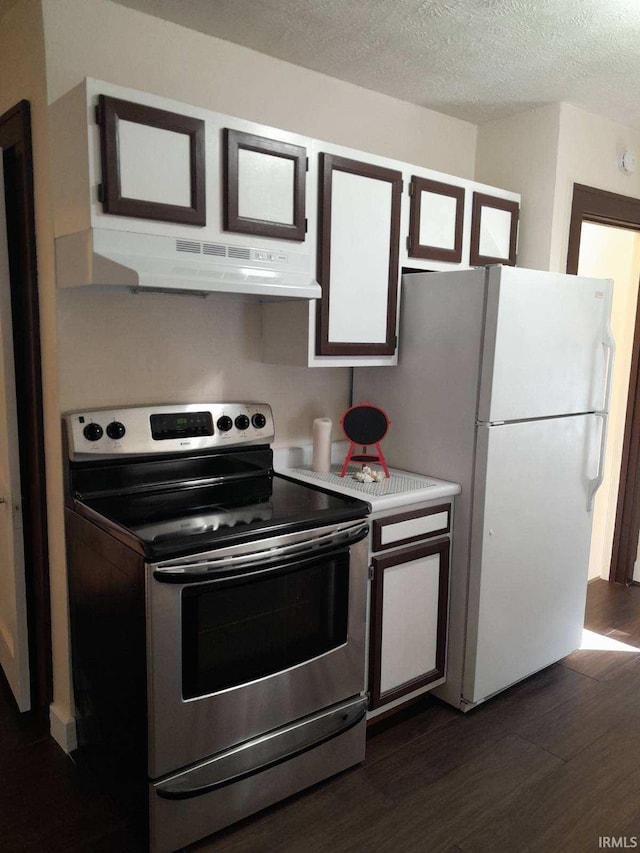 kitchen featuring stainless steel electric stove, dark hardwood / wood-style floors, white fridge, and a textured ceiling