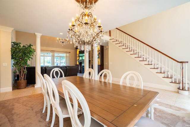 dining area featuring ornate columns, a chandelier, and light tile patterned floors