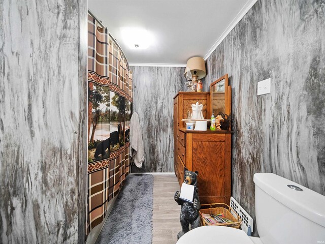 bathroom featuring ornamental molding, hardwood / wood-style floors, and toilet