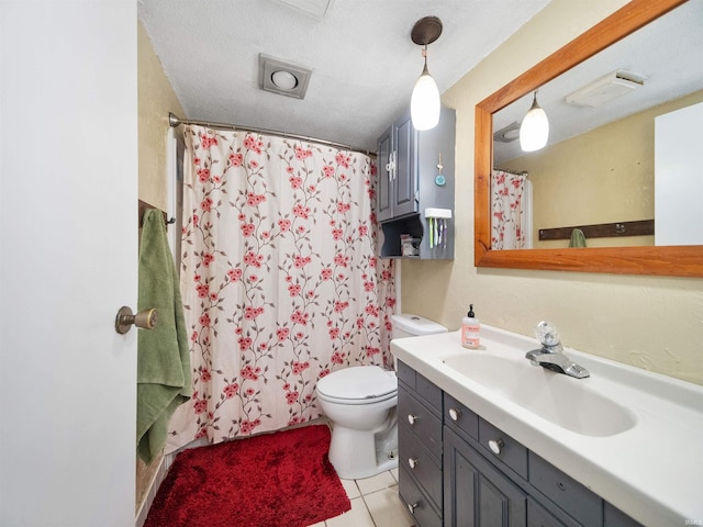 bathroom with tile patterned flooring, toilet, curtained shower, vanity, and a textured ceiling