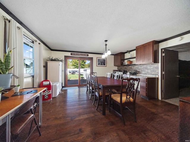 dining space with ornamental molding, dark wood-type flooring, and a textured ceiling