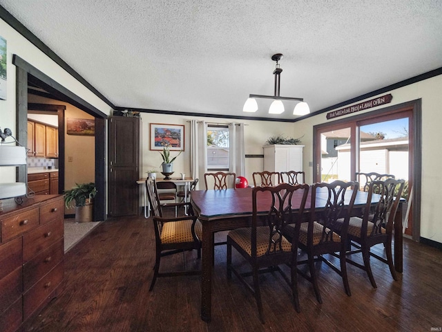 dining space with a textured ceiling, crown molding, dark hardwood / wood-style flooring, and a healthy amount of sunlight