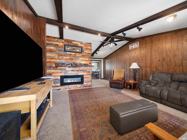 carpeted living room featuring ceiling fan, a textured ceiling, a fireplace, and wood walls