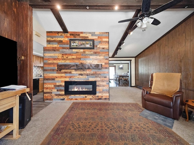 living room with dark carpet, vaulted ceiling with beams, a fireplace, and wood walls