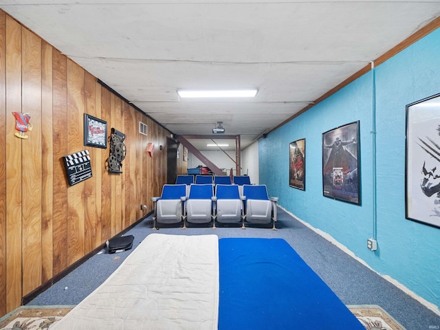 home theater room featuring carpet floors and wooden walls