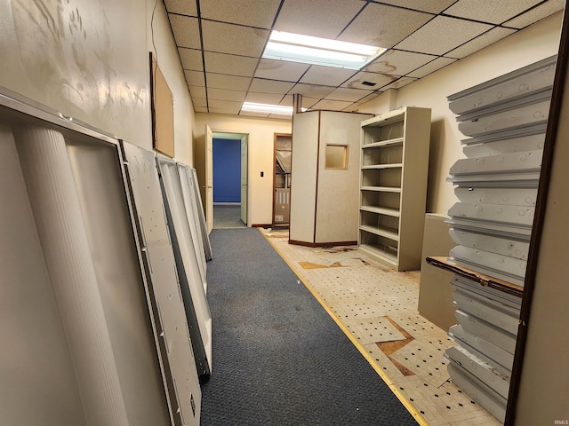 interior space featuring a paneled ceiling and light colored carpet