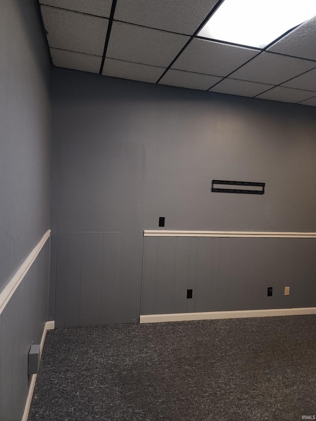 carpeted spare room with a paneled ceiling