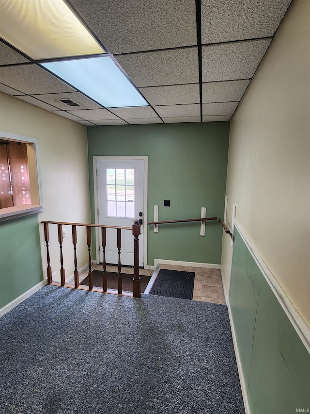 entryway with carpet floors and a paneled ceiling