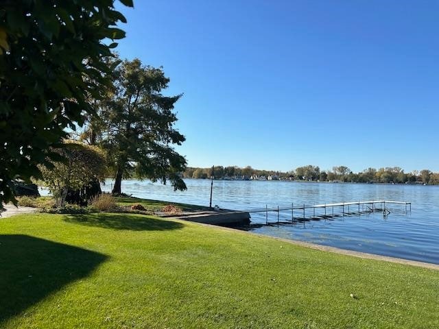 dock area featuring a lawn and a water view